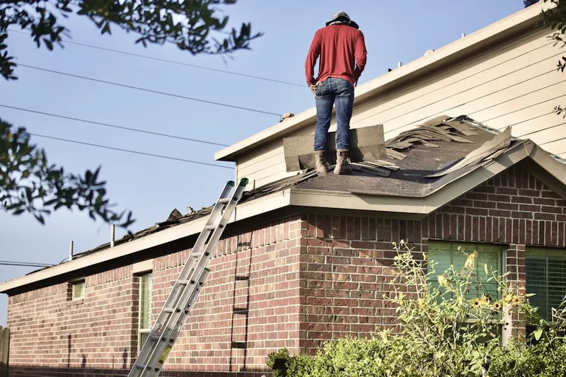 Professional roofer working on a residential roof in Chicopee